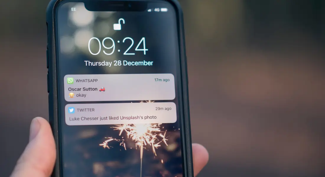 iPhone showing a screenshot of notifications from WhatsApp and Twitter